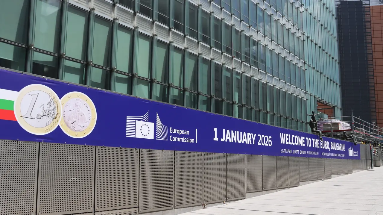A long European Commission banner reading "1 January 2026, Welcome to the euro, Bulgaria" with the Bulgarian one-euro coin, on a glass building in Brussels